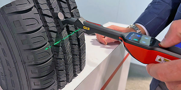 Mechanic using a tyre tread depth gauge during inspection